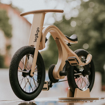 Close-up of leg&go pedal bike showing wooden frame curved design