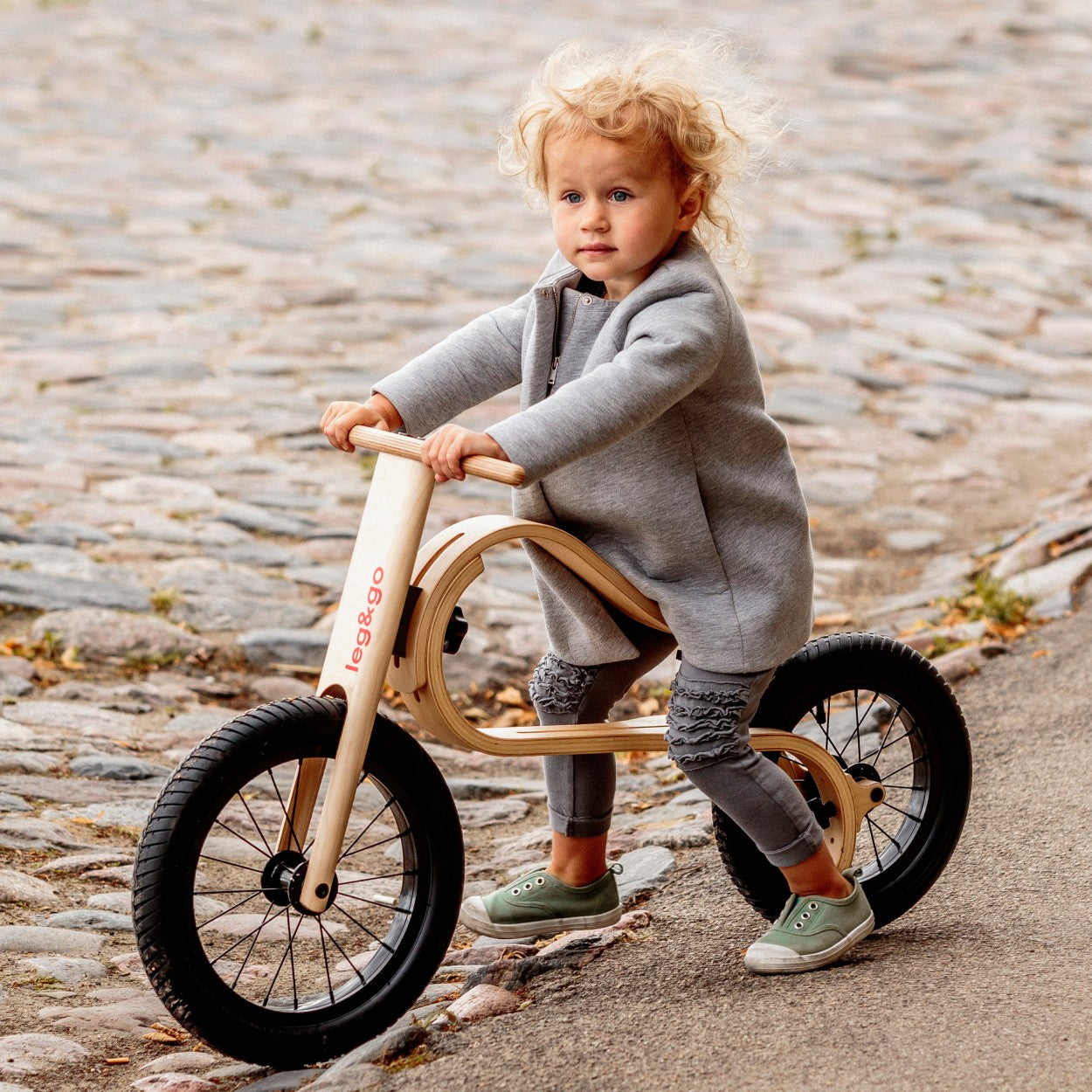 Young toddler sitting on leg&go 3in1 wooden kids bike – size and scale reference for ages 1–3
