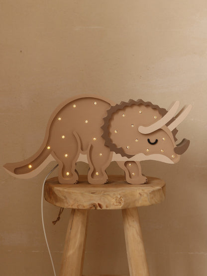 Natural wood triceratops lamp with glowing LED lights displayed on a wooden stool