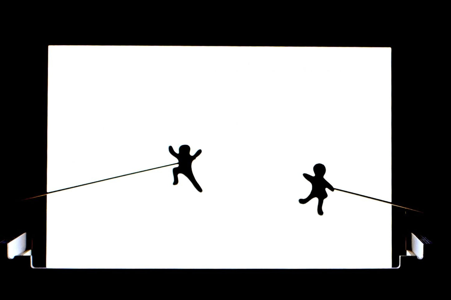 Two stick figures playing on a bright white light board panel