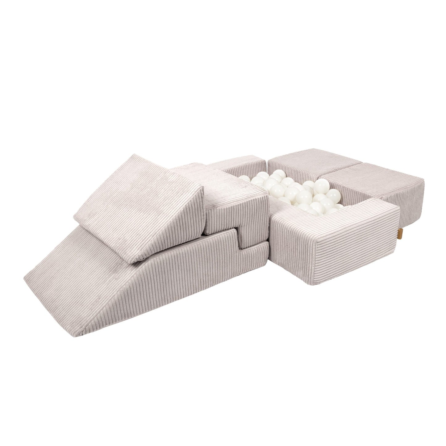 Soft velvet modular bricks assembled as ball pit with cream-colored play balls inside
