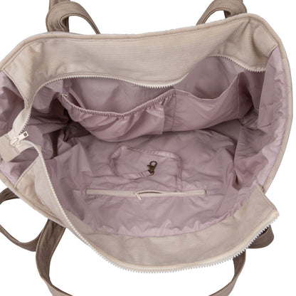 Interior view of beige weekender bag displaying waterproof lining and organized pocket compartments