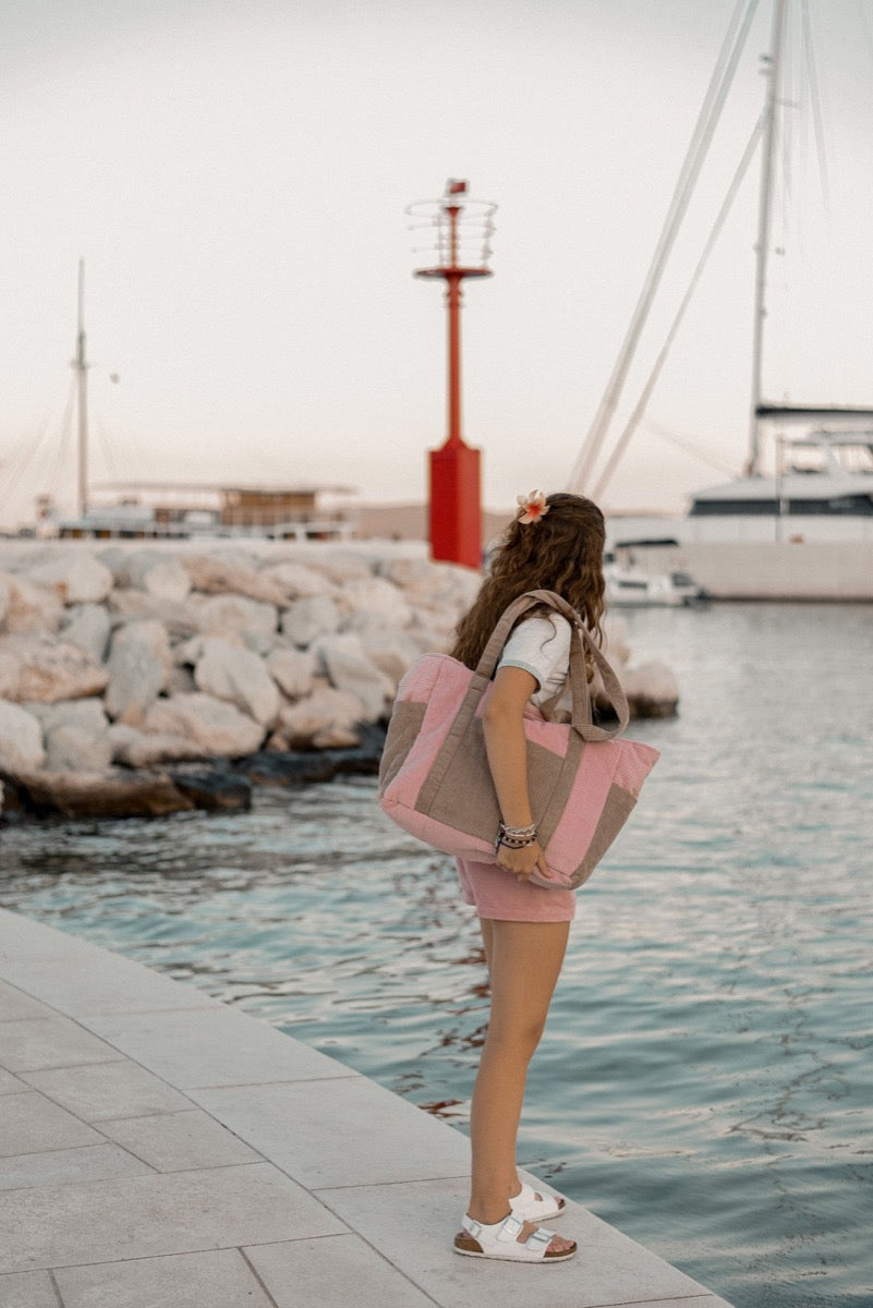 Woman wearing pink coffee mom weekender bag over shoulder by marina