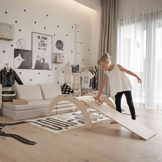 Child balancing on birch wood climbing arch with ramp in modern nursery room