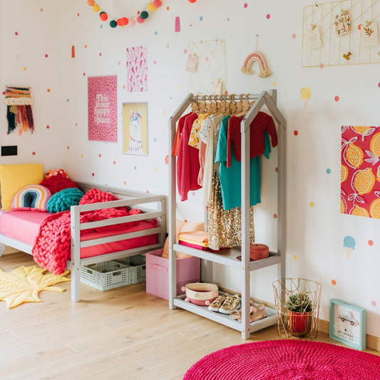 House-shaped clothing rack with storage in white in colorful kids bedroom with bed and wall decorations