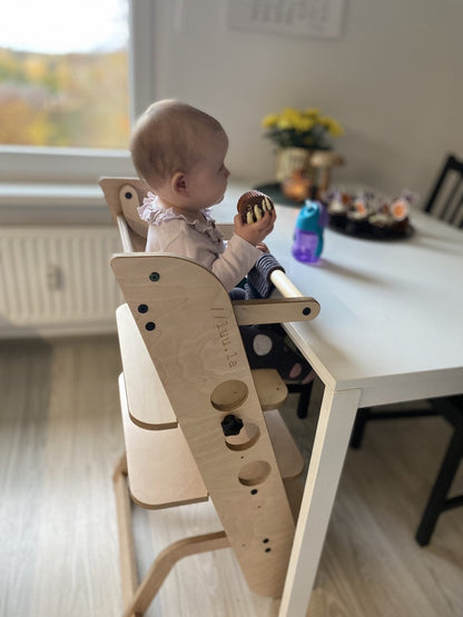 Baby sitting in Louis learning tower high chair configuration with tray attachment