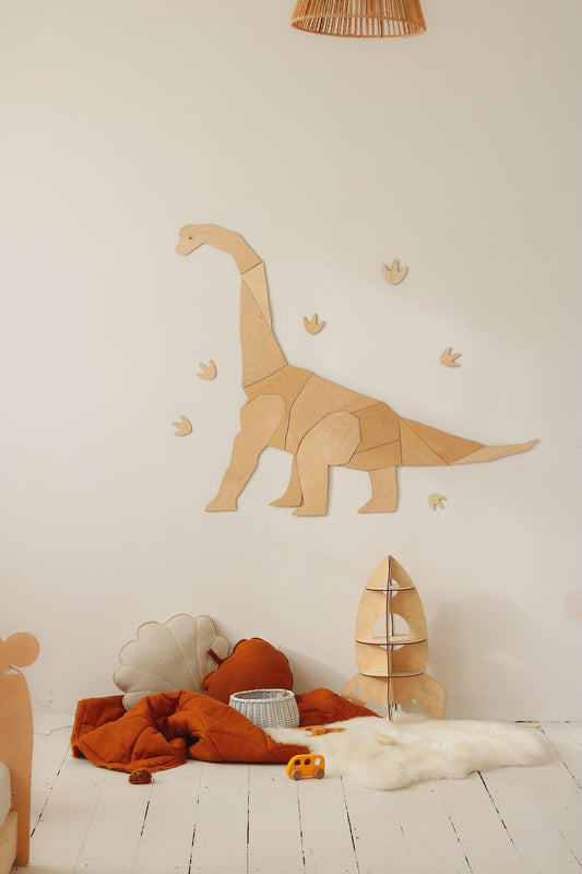 Wooden diplodocus wall decor with footprint details mounted on bedroom wall above toys