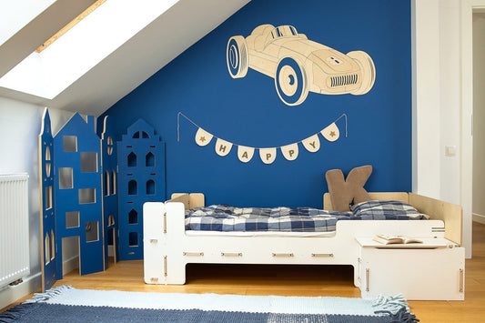 Wooden retro car wall decoration mounted on blue bedroom wall above white bed