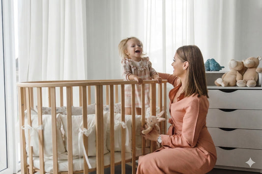 Mother lifting toddler out of round beech wood baby crib in modern nursery