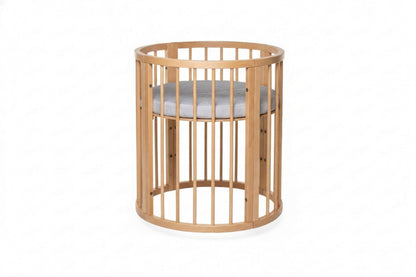 Round beechwood crib with removable side panel and white mattress