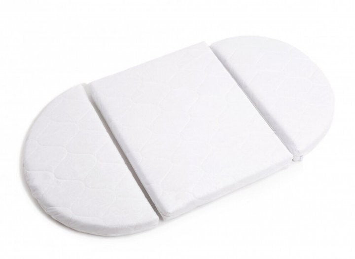 White oval mattress pad designed for round crib with three sections