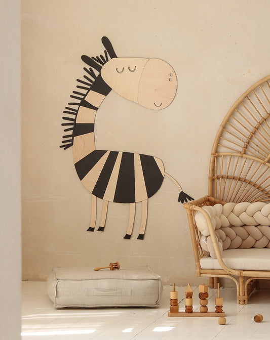 Black and cream wooden zebra wall decoration in playroom with rattan chair