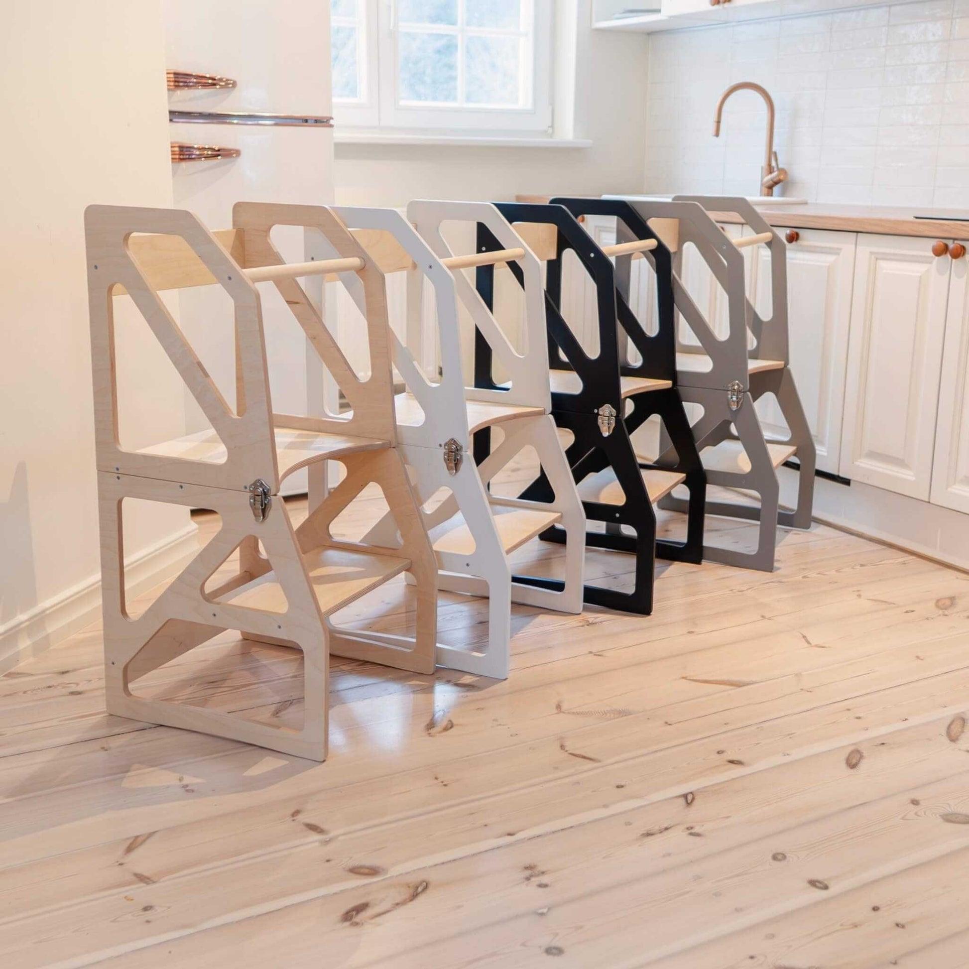 Multiple kitchen tower colors displayed in natural wood, white, and black finishes
