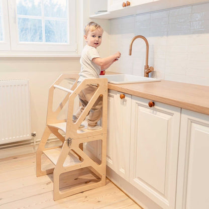 Toddler at sink using natural birch kitchen tower as countertop step stool