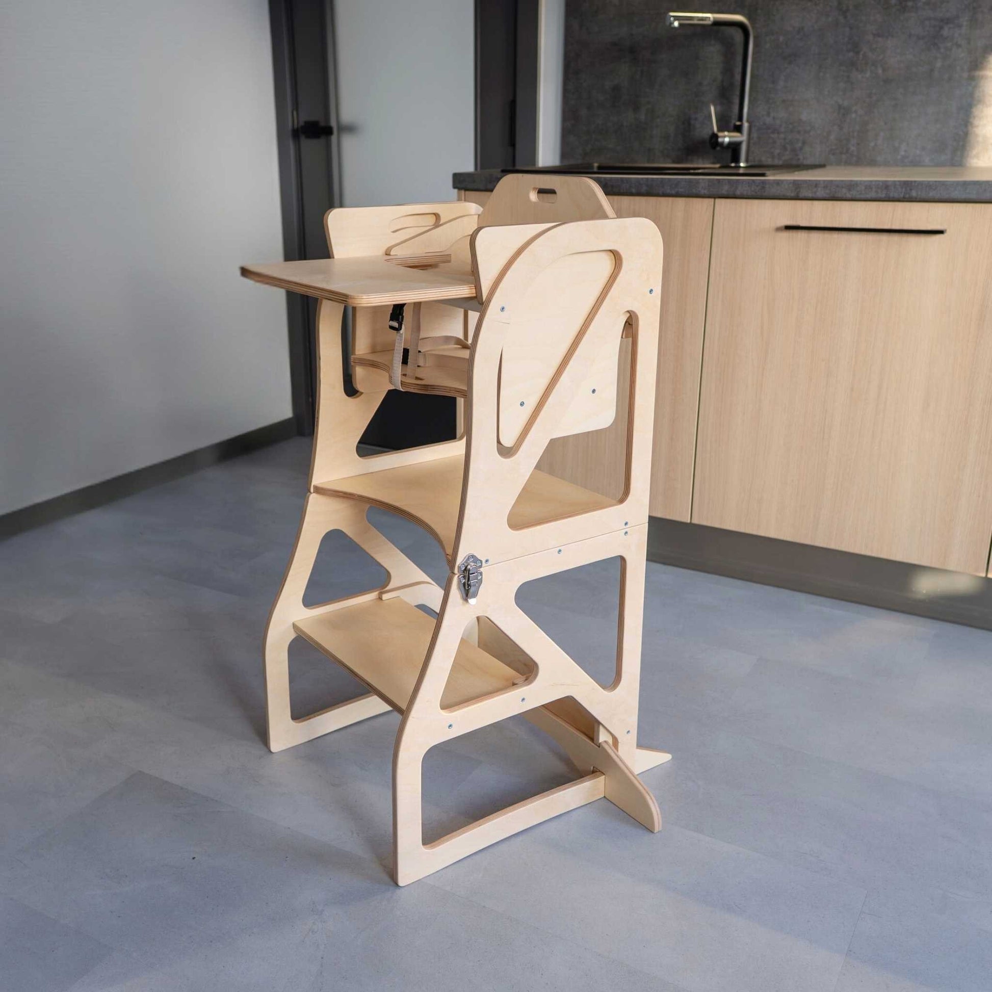 Child at table on gray kitchen tower, elevated seating for counter height