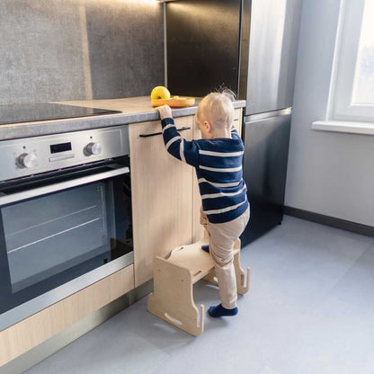 Toddler at grey kitchen tower table playing with toy pattern learning mat