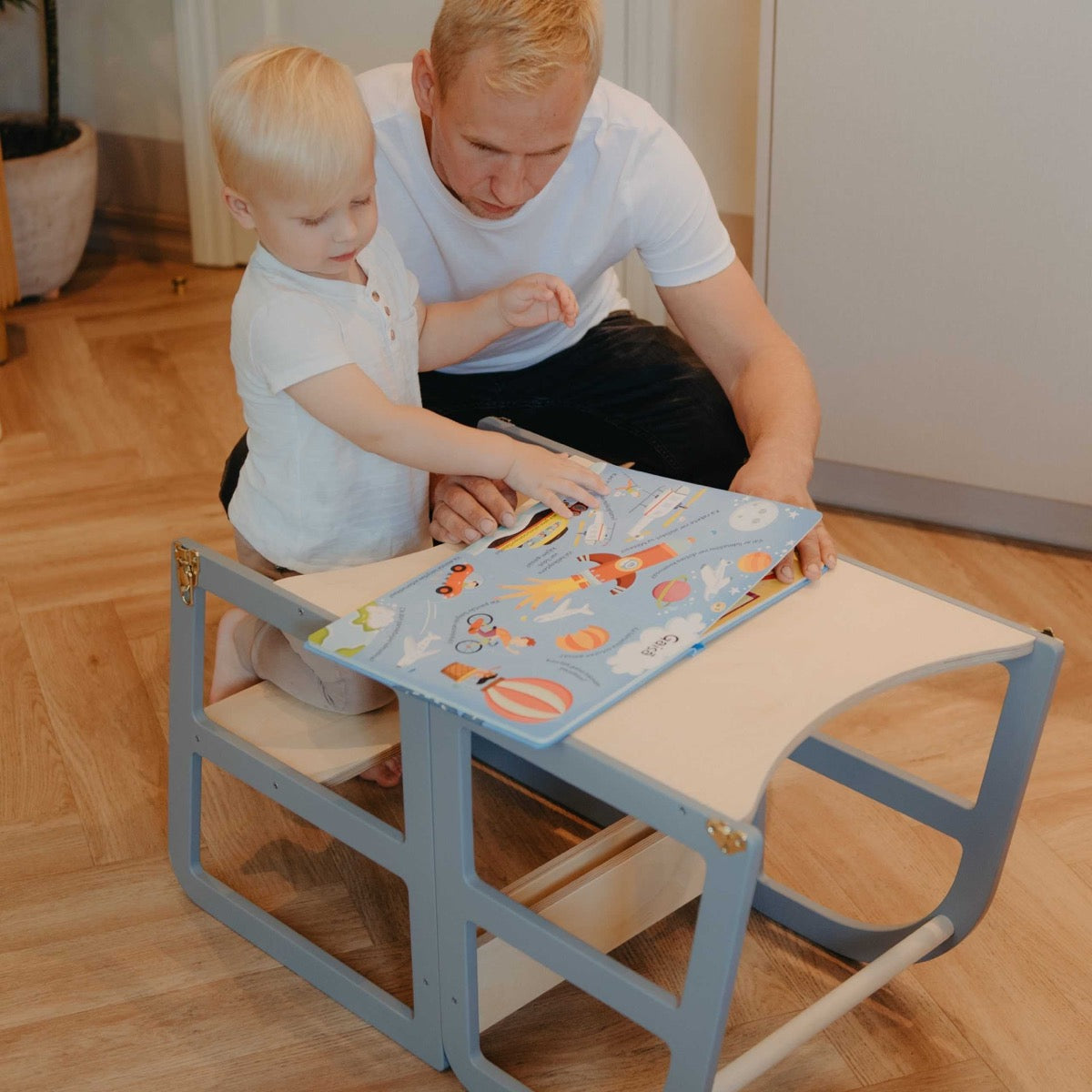 Toddler seated at grey kitchen tower table for independent play and learning