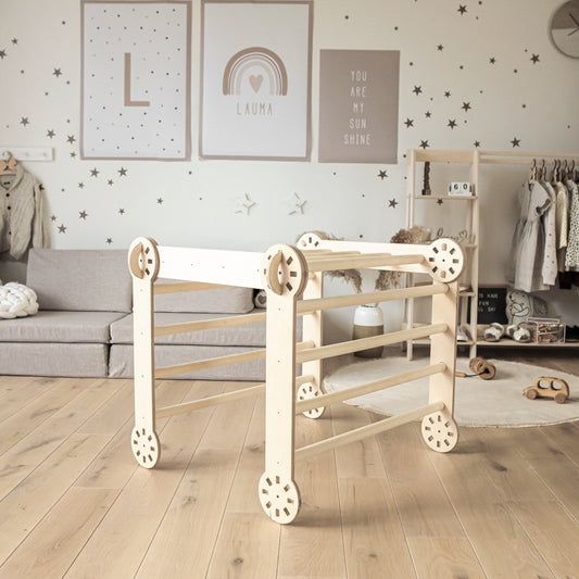 Foldable climbing triangle with ramp set up in a light nursery room with wooden flooring