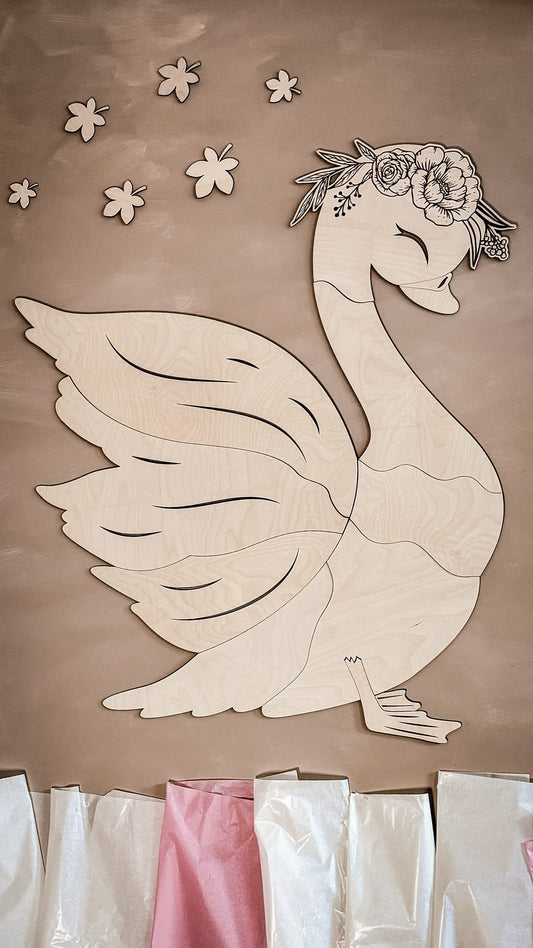 Birch plywood swan wall decoration assembled with floral crown and scattered wooden flower pieces on wall
