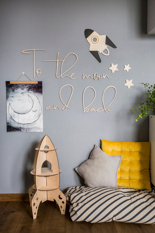 To the Moon and Back wooden wall sign with rocket and stars displayed in nursery with bed